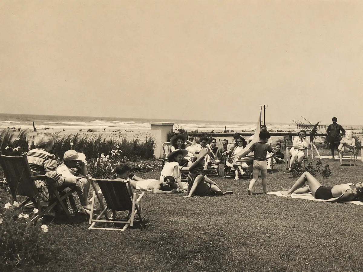 Huéspedes tomando sol en el parque frente al mar, en una foto de época